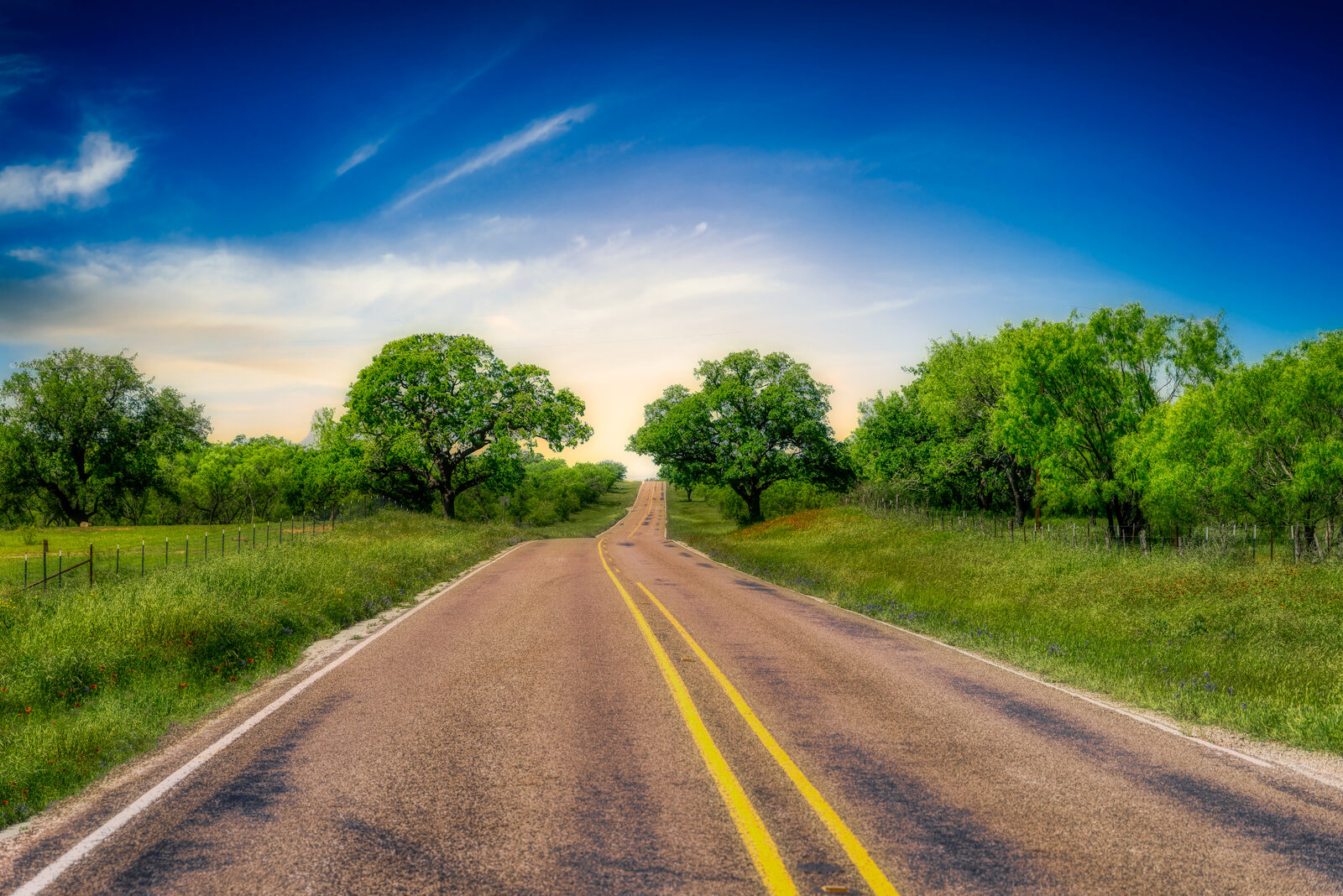 A two-lane road winding through the Texas Hill Country